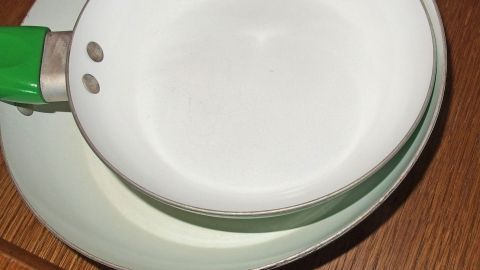 Zum Schmunzeln: Wie sich Töpfe und Pfannen leichter reinigen lassen, verrät euch dieser - nicht ganz ernst gemeinte - Tipp. Eine saubere Pfanne liegt auf einem weißen Teller, beide warten in einer Küche auf die nächste Verwendung.