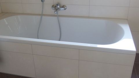 Lässt sich eure Emaille-Badewanne z. B. mit Scheuermilch nicht gut reinigen, dann versucht es mit WC Reiniger. Eine Badewanne steht sauber und unbenutzt in einem hellen Badezimmer, bereit für die Reinigung mit WC-Reiniger.