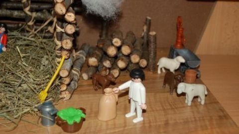 Baue mit den Kindern eine kreative Krippe! In dem Artikel findest du tolle Tipps zur Gestaltung mit einfachen Materialien. Lass deiner Fantasie freien Lauf und freue dich über die gemeinsamen Erinnerungen beim Basteln. Eine kleine Krippe mit Figuren und Tieren wird auf einem Tisch aufgebaut, umgeben von Holzscheiten und Heu.