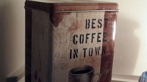 Im Kühlschrank deponiert bleibt der Kaffe superlange frisch. Ein Kaffeebehälter steht im Kühlschrank und bewahrt das Kaffeepulver frisch auf. Der Behälter zeigt den Text "BEST COFFEE IN TOWN".