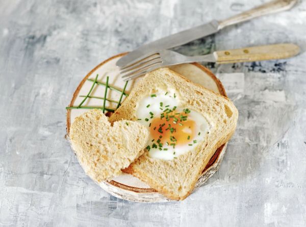 Ein h&uuml;bsch aussehendes, schnelles und leckeres Fr&uuml;hst&uuml;ck: Fr&uuml;hst&uuml;cksei im Toast in einer Herzform.