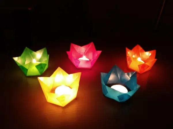 Bunte Papier-Windlichter leuchten sanft auf einem Tisch, schaffen eine festliche Atmosphäre im Advent.