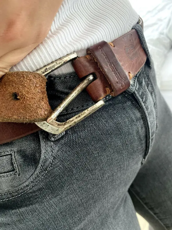 Die G&uuml;rtelnadel wird beim Knoten unter das Band gedr&uuml;ckt.