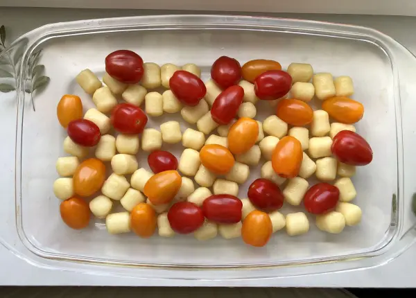 Zuerst den Ofen auf 180 Grad Ober-/Unterhitze vorheizen. Die Gnocchis mit den Cocktailtomaten in eine Auflaufform geben.