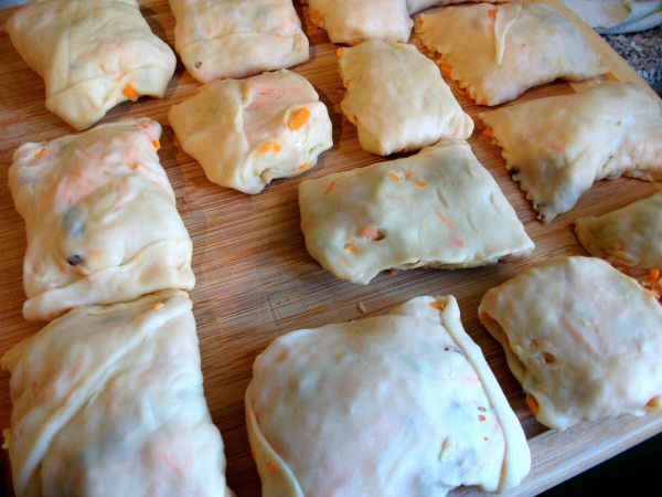 Die Teigtaschen aufrollen oder einschlagen wie Maultaschen. Dann mit einem Teigr&auml;dchen die Taschen trennen.