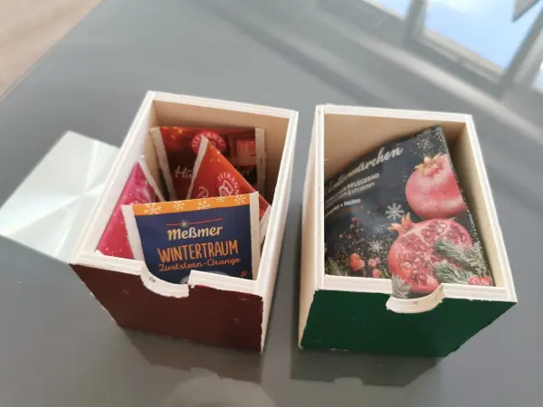 Zwei Schubladen befüllt mit Wintertee und Badezusatz – ein wenig geknickt, damit es passt.