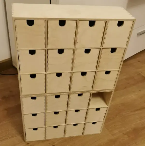 Zwei Kommoden mit jeweils 12 kleinen Schubladen werden mithilfe der Heißklebepistole zusammengeklebt.