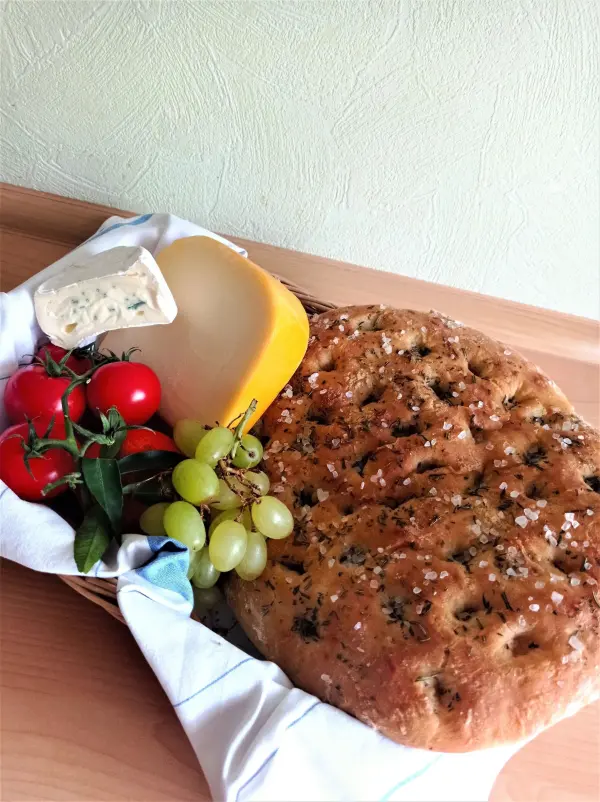 Ist die Focaccia fertig gebacken, kann man sie lauwarm ohne alles essen oder man verzehrt sie zum Beispiel mit würzigem Käse.