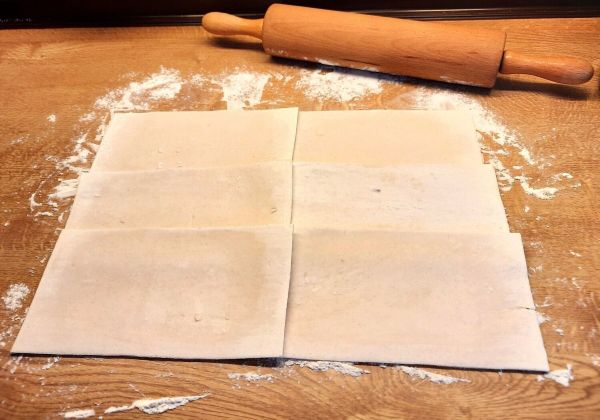 Die Arbeitsfl&auml;che wird leicht mit Mehl bestreut und die Teigplatten werden &uuml;berlappend ausgewellt.