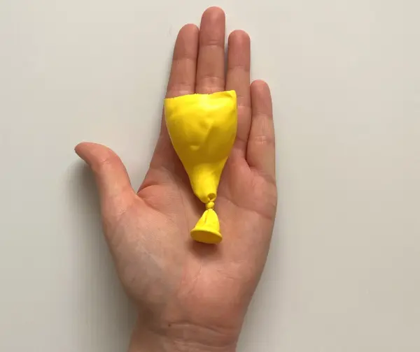 In den zerschnittenen Luftballon machst du einen Knoten, denn jetzt geht's ans Zusammenbauen.
