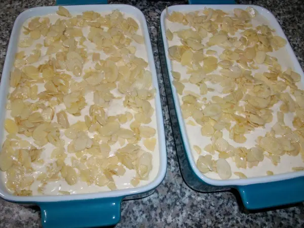 Die leicht ger&ouml;steten und karamellisierten Mandelbl&auml;ttchen auf dem Ofenschlupfer verteilen.