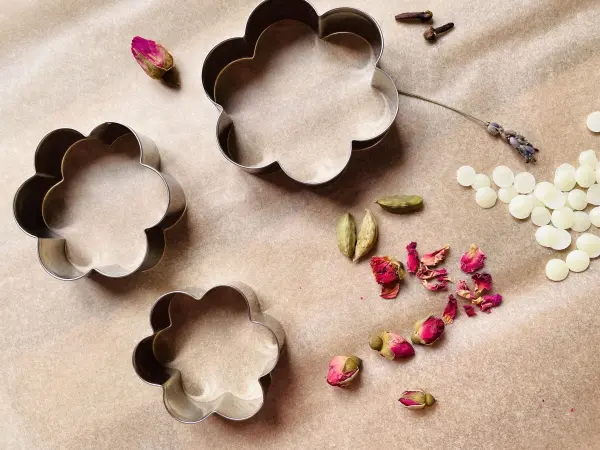 Alles bereit f&uuml;r duftende Wachsanh&auml;nger: Bienenwachs, Keksausstecher und getrocknete Bl&uuml;ten von Rosen und Lavendel. DIY Spa&szlig; wartet!