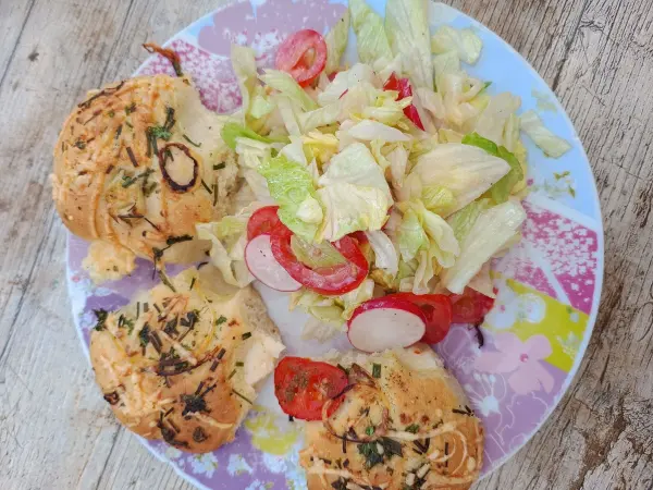 Handliche Fingerfood-St&uuml;cke der Pizzablume mit Beilagensalat auf einem Teller serviert.
