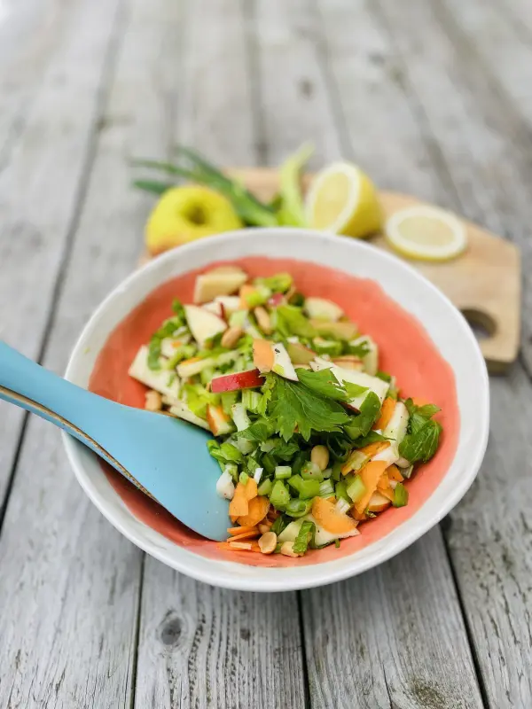 Sch&uuml;ssel mit frischem Apfel-Sellerie-Salat: Datteln, Chili, Erdn&uuml;sse und Zitrone geben dem Salat eine besondere Note.