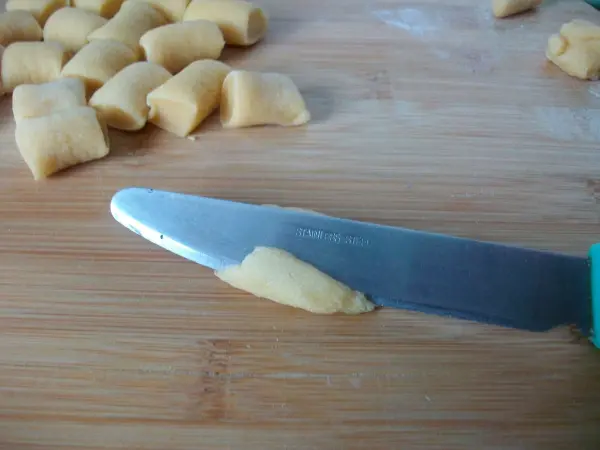 Orecchiette formen: Sanften Druck mit dem Buttermesser h&auml;lt man und wischt gleichzeitig &uuml;ber den Teig, so rollen sich die Seiten ein.