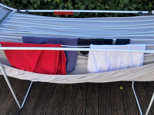 Spannbettlaken clever aufhängen: Vermeide Falten und spar Platz, indem du alles, wie im Bild gezeigt, über den Wäscheständer hängst. So trocknet alles gleichmäßig und du nutzt den Platz optimal aus. Spannbettlaken clever aufgehängt: Nutze den Platz unter dem Wäscheständer, um oben schnell Wäsche zu trocknen.
