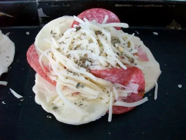 Mit Eigelb den Blätterteiganteil bestreichen. Blume mit geriebenem Käse, die Käsesorte nach eigenem Geschmack bestreuen. Mit Eigelb den Blätterteiganteil bestreichen. Blume mit geriebenem Käse, die Käsesorte nach eigenem Geschmack bestreuen.