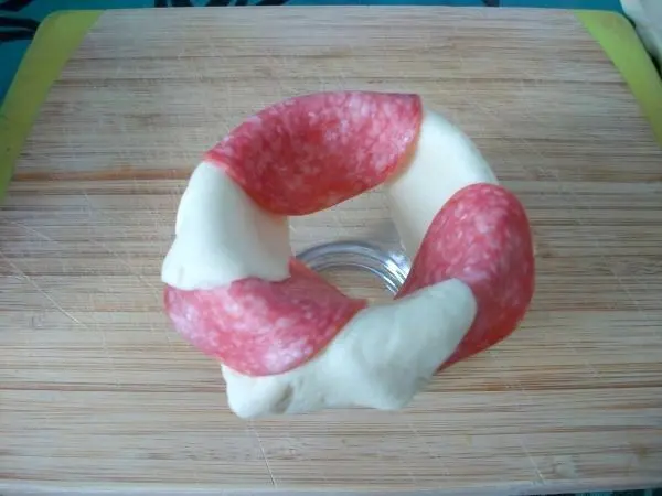 Nun nimmt man ein Trinkglas und belegt den Rand abwechselnd mit Salami und Blätterteig. Ich hatte je 3 Scheiben verwendet. Nun nimmt man ein Trinkglas und belegt den Rand abwechselnd mit Salami und Blätterteig. Ich hatte je 3 Scheiben verwendet.