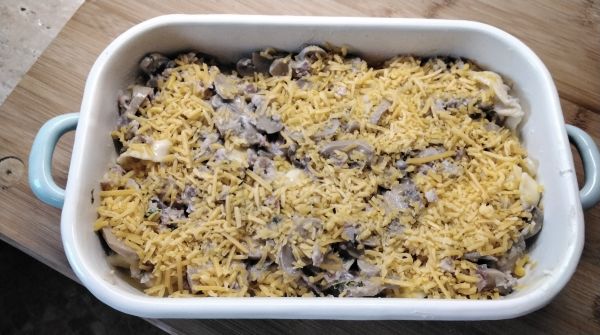 In die gebutterte Auflaufform kommen die Tortellini. Mit der B&eacute;chamelso&szlig;e bedeckten, oben den geriebenen Cheddar-K&auml;se aufstreuen. 