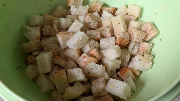 F&uuml;r die Cro&ucirc;tons werden Toastbrotw&uuml;rfel, Speckw&uuml;rfel, Knoblauch- und Basilikum&ouml;l sowie Salz und Nuss-Creme gemischt.