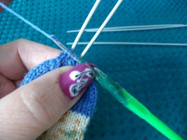 Die restlichen zwei Maschen je Nadel gebe ich auf meine kleine H&auml;kelnadel, hole den Faden und ziehe ihn durch die Maschen.