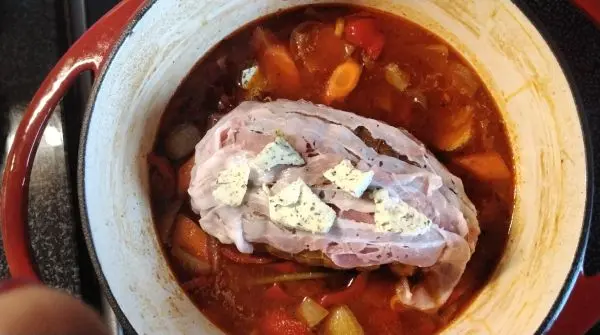 Der gewürzte Rollbraten wird in den Soßenansatz gelegt. Oben auf habe ich ein paar Gewürz-Butter-Stücke gelegt. Der gewürzte Rollbraten wird in den Soßenansatz gelegt. Oben auf habe ich ein paar Gewürz-Butter-Stücke gelegt.