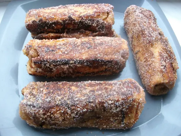 Wenn die Rollen auf allen Seiten goldgelb angebraten sind, wälzt man sie im Mix aus dem restlichen Rohrzucker, Zucker und Zimt. Wenn die Rollen auf allen Seiten goldgelb angebraten sind, wälzt man sie im Mix aus dem restlichen Rohrzucker, Zucker und Zimt.
