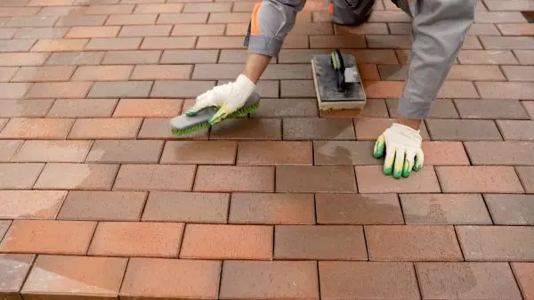 Mit einer Terrassenb&uuml;rste oder einem Schrubber kannst du Wasser und ph-neutrale Seife einb&uuml;rsten, um Schmutz zu entfernen.