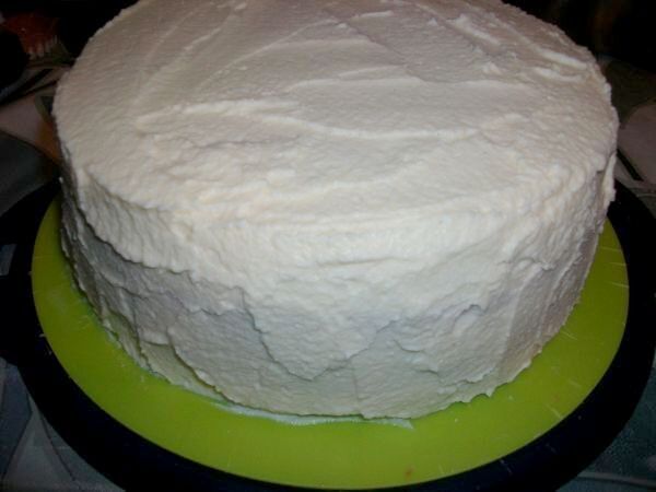 Den vierten Biskuit auf die Torte geben und mit der wei&szlig;en Ganache-Creme m&ouml;glichst gleichm&auml;&szlig;ig einstreichen. Dann ca. 1 Std. k&uuml;hlen.