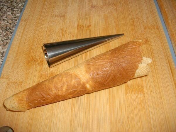 Die d&uuml;nne Waffel mit mithilfe einer Edelstahl-T&uuml;te zu einer Eiserwaffel geformt.