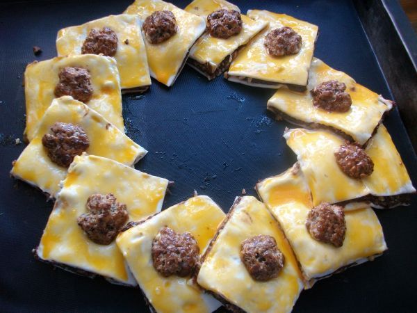 Die Teilchen &uuml;berlappend im Kreis zu einem Kranz aneinanderlegen. Mit Eigelb bestreichen und die 12 Waln&uuml;sse verteilen.