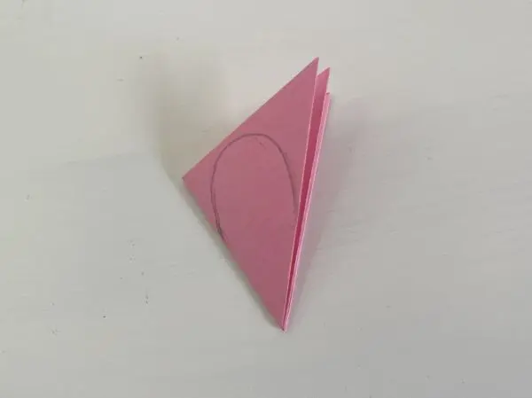 Auf die Faltung zeichnest du ein Rosenblatt auf und schneidest es aus, sowie die untere Spitze ab. Auf die Faltung zeichnest du ein Rosenblatt auf und schneidest es aus, sowie die untere Spitze ab.
