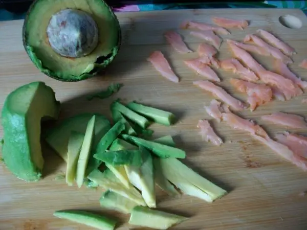 Die halbe Avocado in kleine Stücke schneiden und die Lachsscheibe ebenso in kleine Stücke vorbereiten. Die halbe Avocado in kleine Stücke schneiden und die Lachsscheibe ebenso in kleine Stücke vorbereiten.