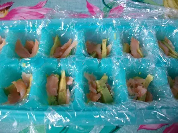 Jetzt gibt man in jedes Eiswürfelfach etwas vom Lachs und auch noch etwas von den Avocadostücken. Jetzt gibt man in jedes Eiswürfelfach etwas vom Lachs und auch noch etwas von den Avocadostücken.