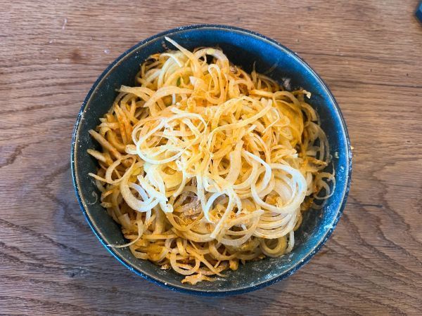 Je feiner die Zwiebelringe, desto knuspriger werden die R&ouml;stzwiebeln. Im Anschluss werden sie mit Mehl und Paprikapulver vermengt.