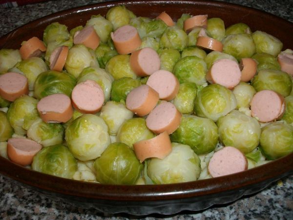 Dann schneide ich die Saiten (auch Wiener W&uuml;rstchen genannt) in kleine Scheiben und verteile sie ebenfalls auf dem Auflauf.