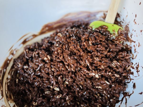Der Puffreis ger&uuml;hrt, bis sich die Schokolade gleichm&auml;&szlig;ig auf dem gepufften Reis verteilt hat.