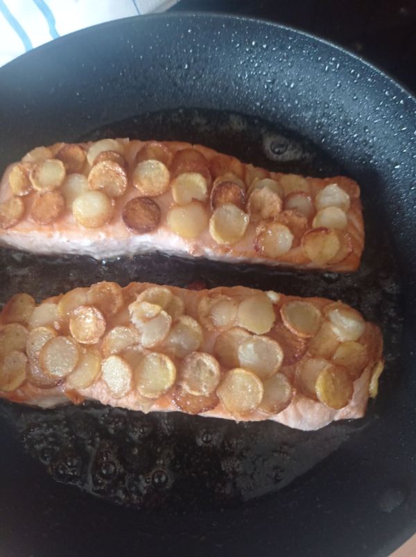 Die Lachsfilets werden von beiden seiten angebraten und dann mit den Kartoffelschuppen best&uuml;ckt.