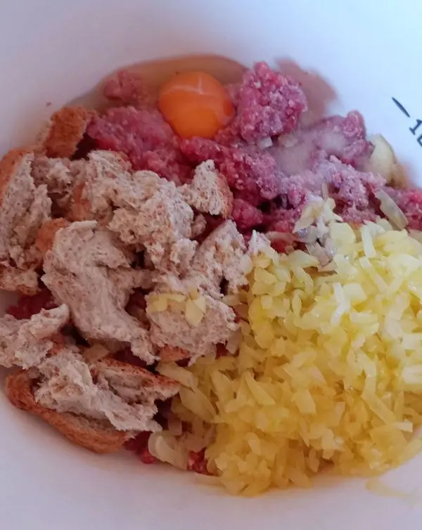 In die Hackfleischmasse kommen die 2 Zwiebeln, die ich in feine W&uuml;rfel geschnitten habe, sowie Salz, Pfeffer und Ei.