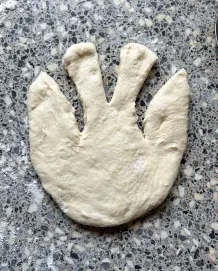 Um die Arme der Osterhasen zu bilden, schneidet man neben den Ohren schräg ein.