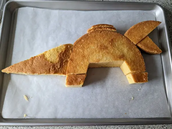 Auf einem Backblech mit Backpapier auslegen und die Kuchenteile zusammenbauen.