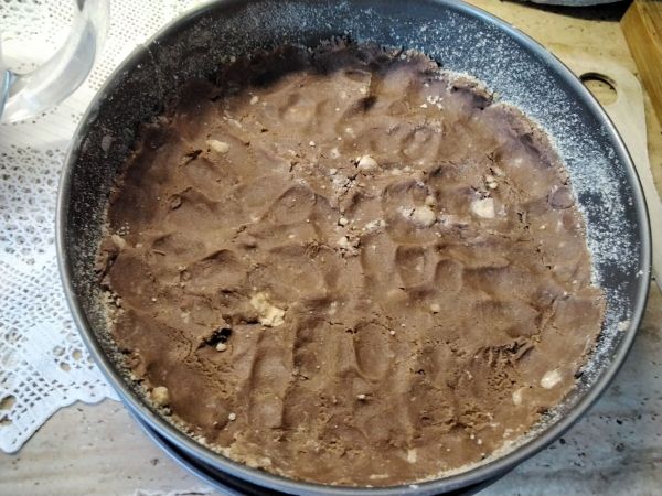 In die gefettete, mit Br&ouml;sel aus gestreute Springform, die Streusel als Boden andr&uuml;cken.