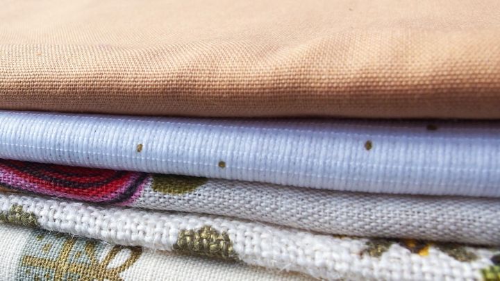 Gestapelte Tischdecken aus verschiedenen Stoffen, sorgf&auml;ltig aufbewahrt und vorbereitet f&uuml;r die Lagerung mit Pappe.