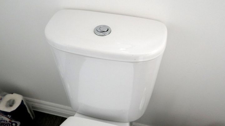 Ein Toilettensp&uuml;lkasten steht sauber und ordentlich an einer Wand. Er ist bereit f&uuml;r die Reinigung mit Gebissreiniger.