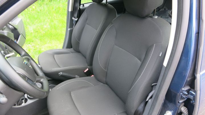 Zwei graue Autositze stehen unbenutzt auf einer Wiese, bereit, Kaugummi mit Waschbenzin zu entfernen.