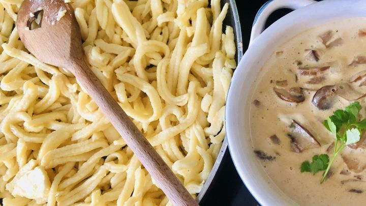 Frischer Sp&auml;tzlesteig liegt neben einer cremigen Pilzsauce in einer Sch&uuml;ssel, bereit zum Servieren.