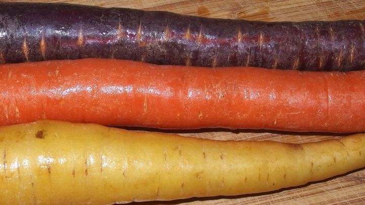 Buntes Gem&uuml;se, darunter Karotten in verschiedenen Farben, liegt auf einem Holzbrett, bereit zum Blanchieren.