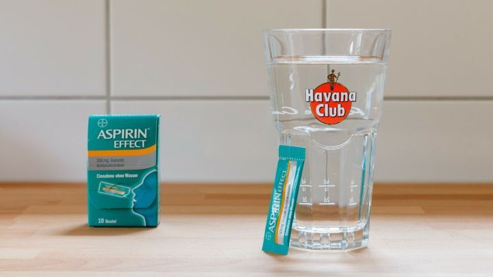 Eine Aspirin-Effect-Packung steht links neben einem Havana Club Glas mit Wasser, passend zum Thema Katerstimmung vermeiden.