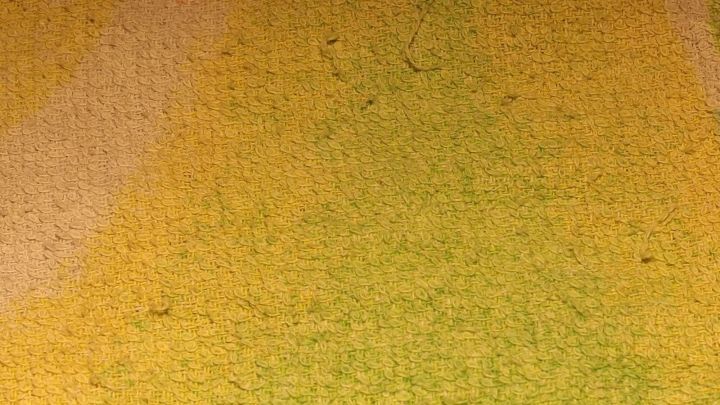 W&auml;sche liegt in einer gelben, gefleckten Oberfl&auml;che, w&auml;hrend Geschirrsp&uuml;ltabs zur Entf&auml;rbung genutzt werden.