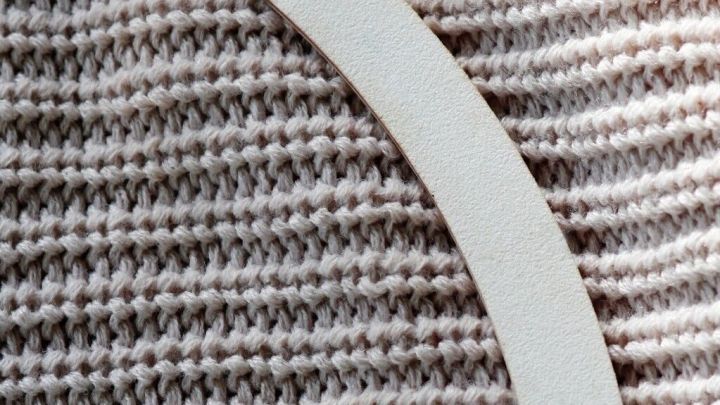 Eine Nagelfeile liegt auf einem gestreiften, grauen Stoff und eignet sich zum Entfernen von Fusseln.